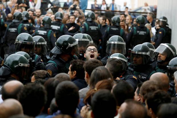 Scuffles break out as Spanish Civil Guard officers force their way through a crowd and into a polling station for the banned independence referendum in Sant Julia de Ramis