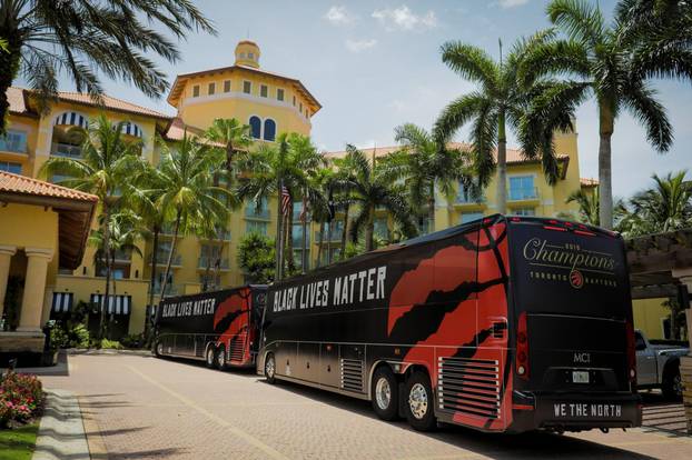 The team buses of the NBA champions Toronto Raptors basketball team arrive at the Walt Disney World complex