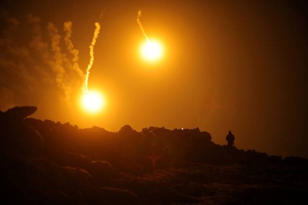 FILE PHOTO: Flares are seen in the sky during fighting in the Islamic State's final enclave, in the village of Baghouz