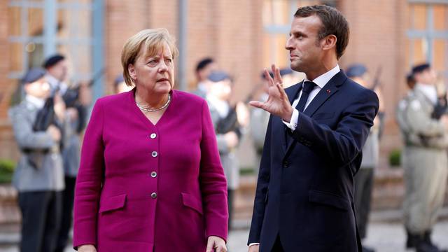 FILE PHOTO: French President Emmanuel Macron welcomes German Chancellor Angela Merkel before a joint Franco-German cabinet meeting in Toulouse