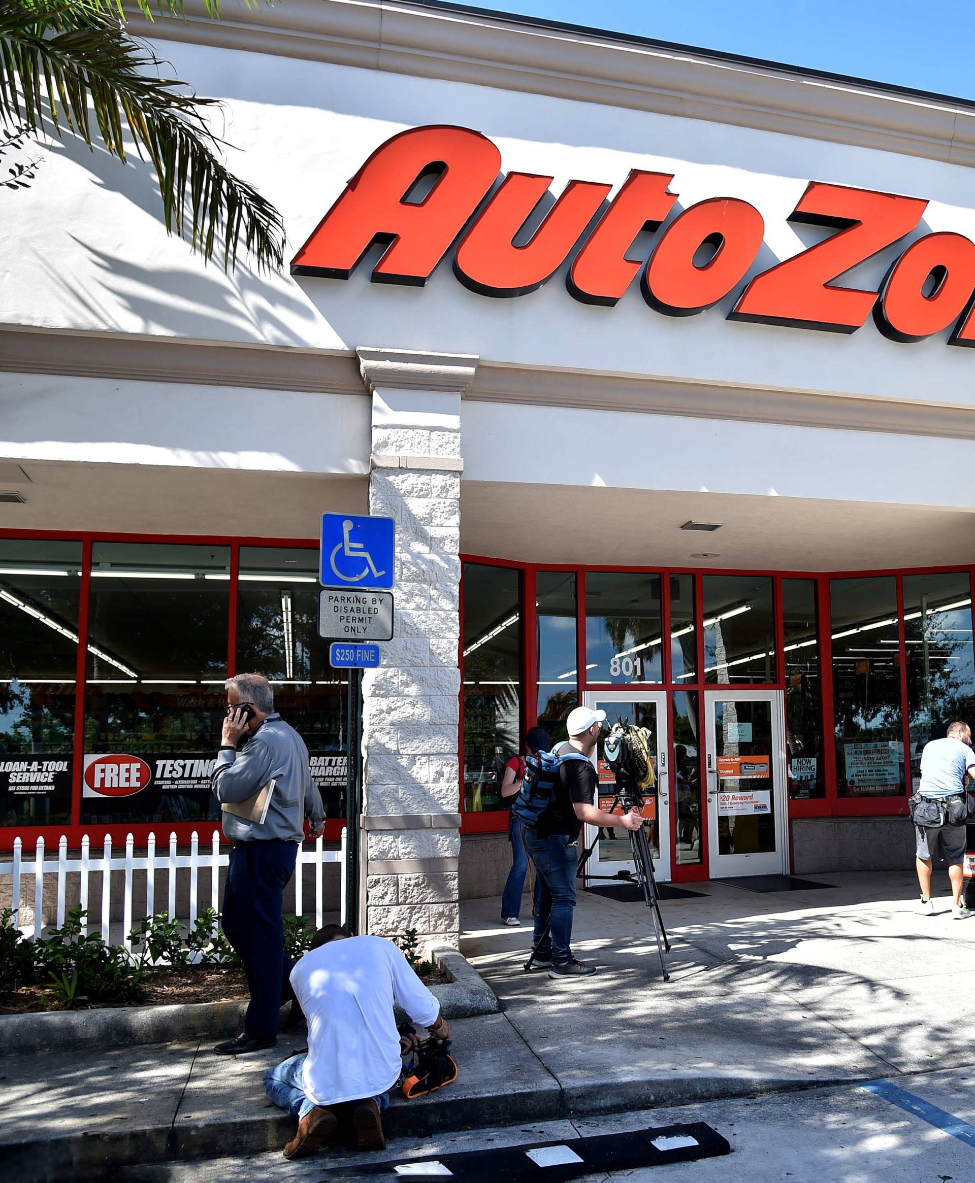 Members of the media are seen outside the Auto Zone store where a suspect involved in an investigation into a string of parcel bombs was apprehended, in Plantation, Florida