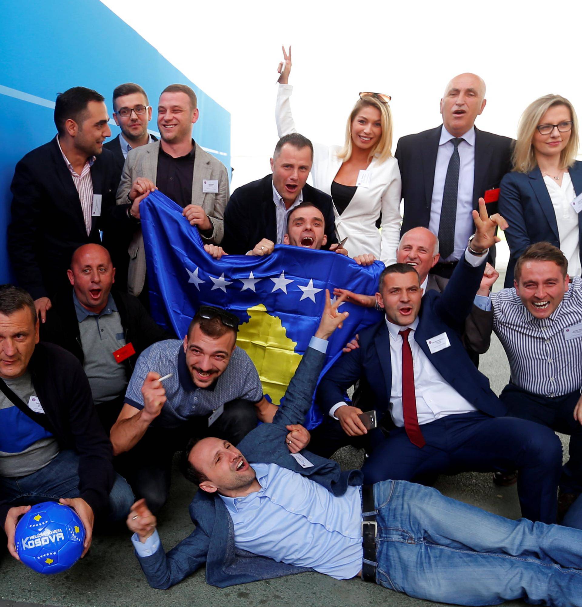 Members of the Kosovo media team celebrate outside the convention centre where the European football group UEFA admitted Kosovo as its newest member in Budapest
