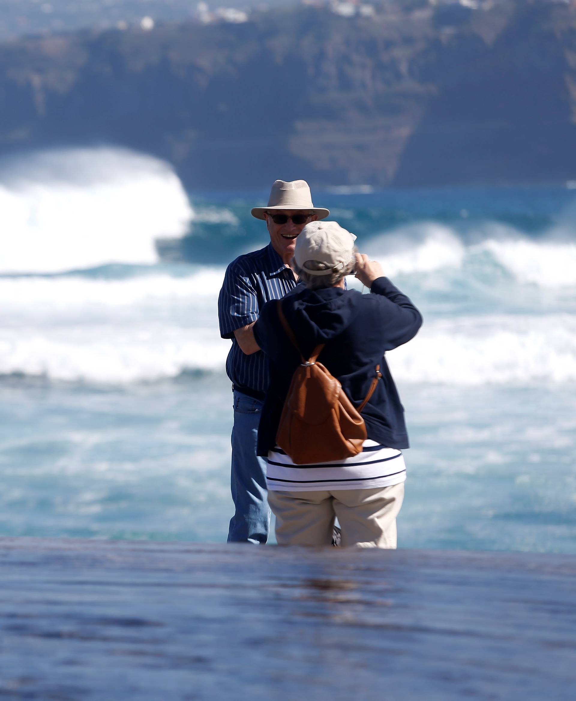Tourists take photos in Martianez beach on the island of Tenerife in Spain's Canary Islands