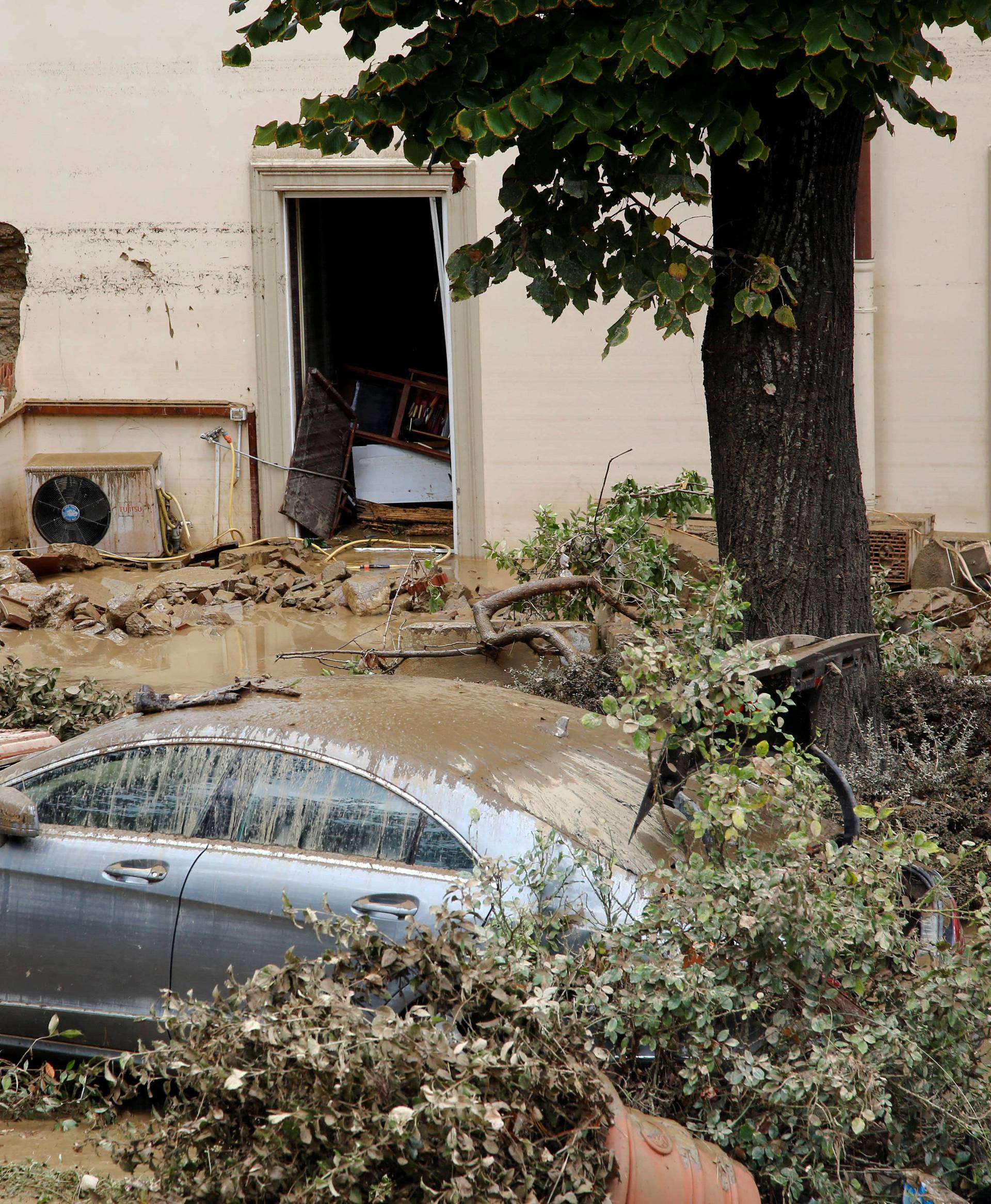 Damaged house and car are seen following floods in Livorno