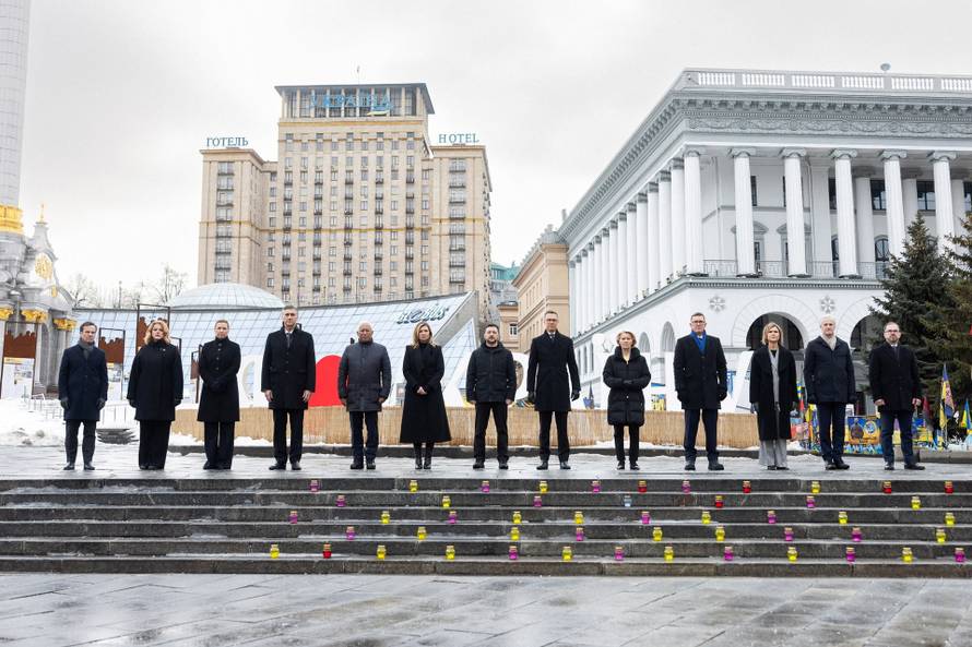 Ukraine's President Zelenskiy his wife Olena and foreign leader visit a makeshift memorial to fallen Ukrainian defenders at the Independent Square on the fourth anniversary of Russia's full-scale invasion, in Kyiv