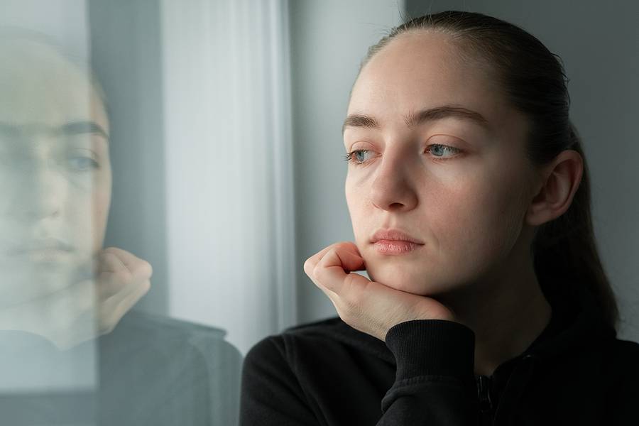 Young Beautiful Woman Looking Through A Window. Lonely Woman Fee