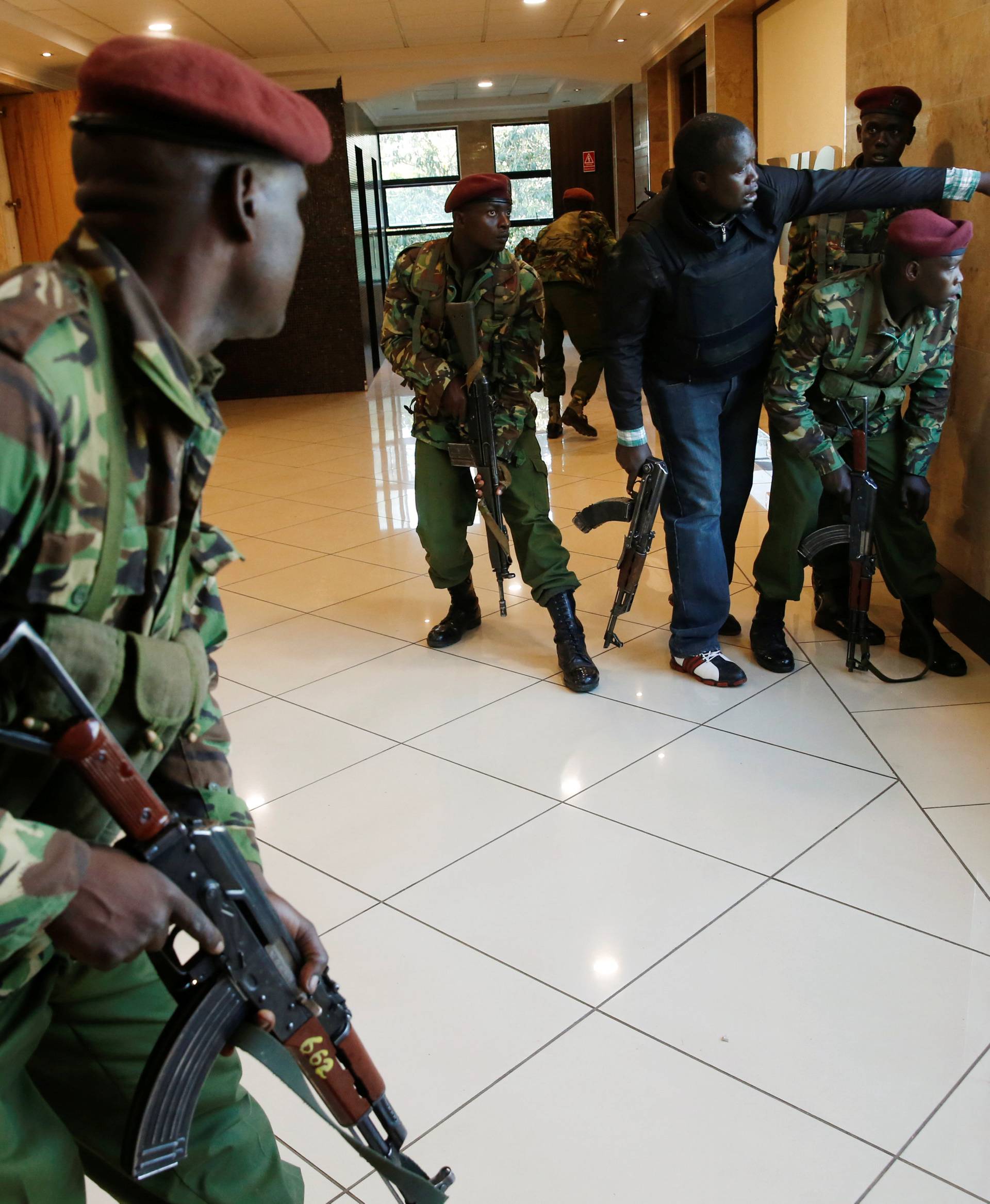 Members of security forces secure a building at the scene where explosions and gunshots were heard at the Dusit hotel compound