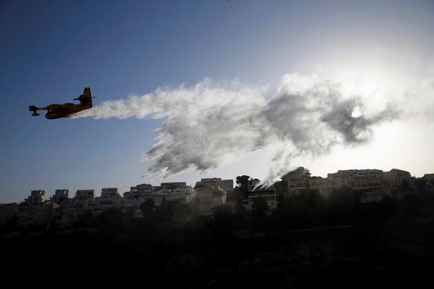 A firefighting plane drops fire retardant during wildfire over the northern city of Haifa