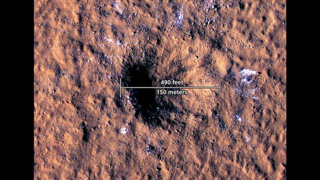 An impact crater about 490 feet (150 meters) across, formed December 24, 2021, by a space rock that struck in the Amazonis Planitia region of Mars, is seen in this annotated image taken by the High-Resolution Imaging Science Experiment