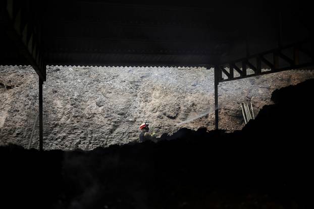 A firefighter works at a partially burnt down cattle farm after a wildfire devastated the area, in Uiseong