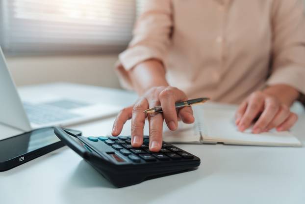 Close,Up,Of,Woman's,Hands,Calculating,Numbers,On,A,Desktop
