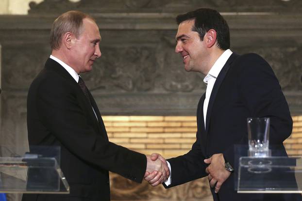 Greek Tsipras shakes hands with Russian President Putin, after a news conference at the Maximos Mansion in Athens