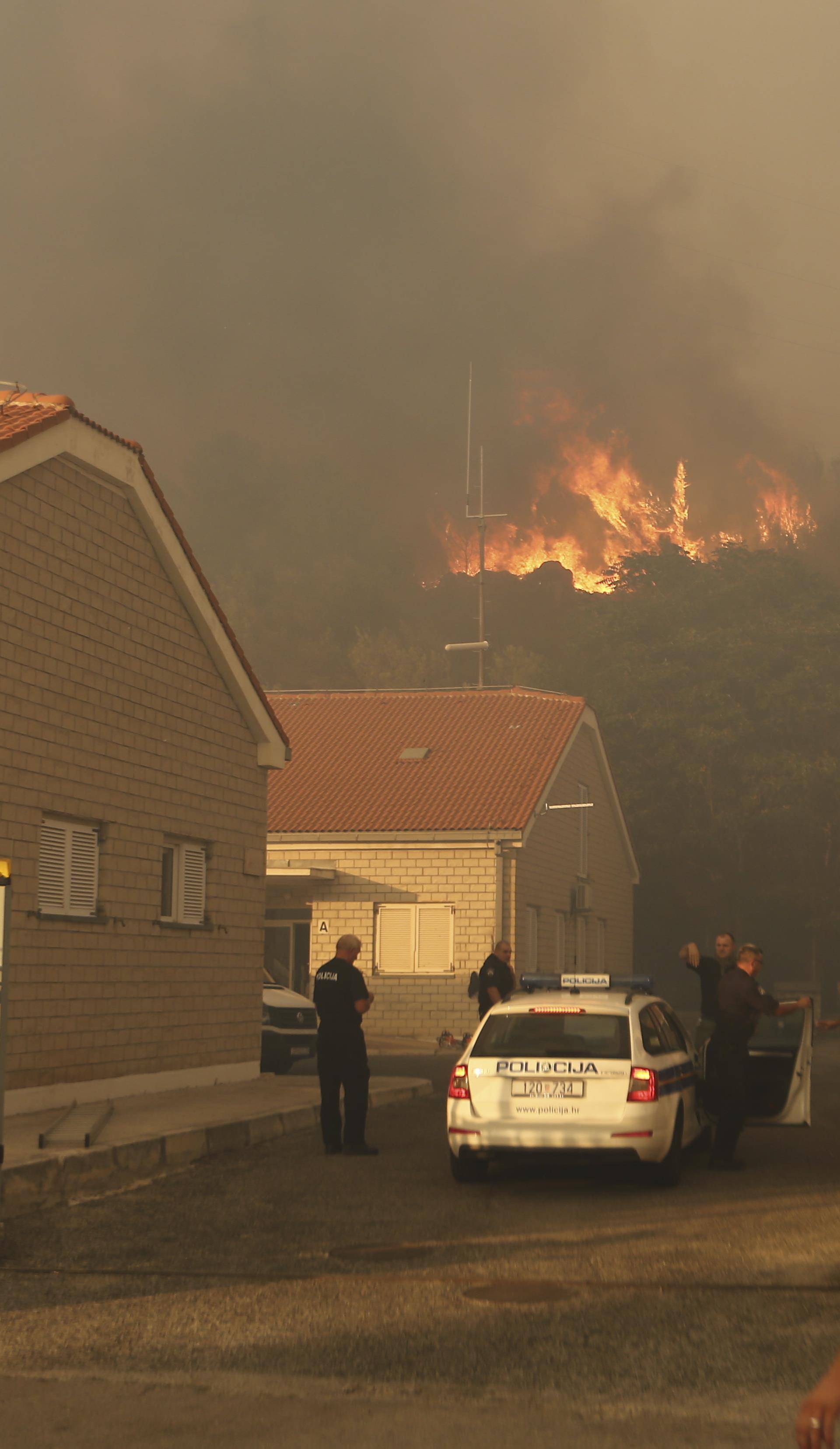 Police officers watch a wildfire in the village of Mravince near Split,