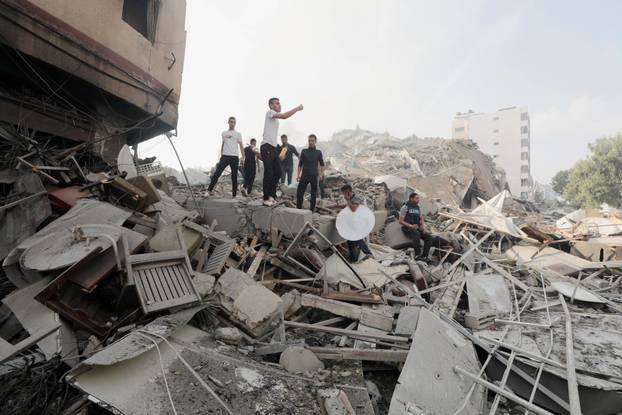 Palestinians inspect the ruins of Watan Tower destroyed in Israeli airstrikes Palestinians inspect the ruins of Watan To