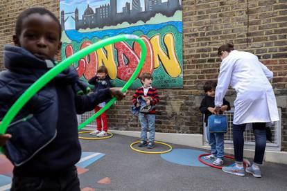 Children use hoops for social distancing at L'Ecole Des Petits school