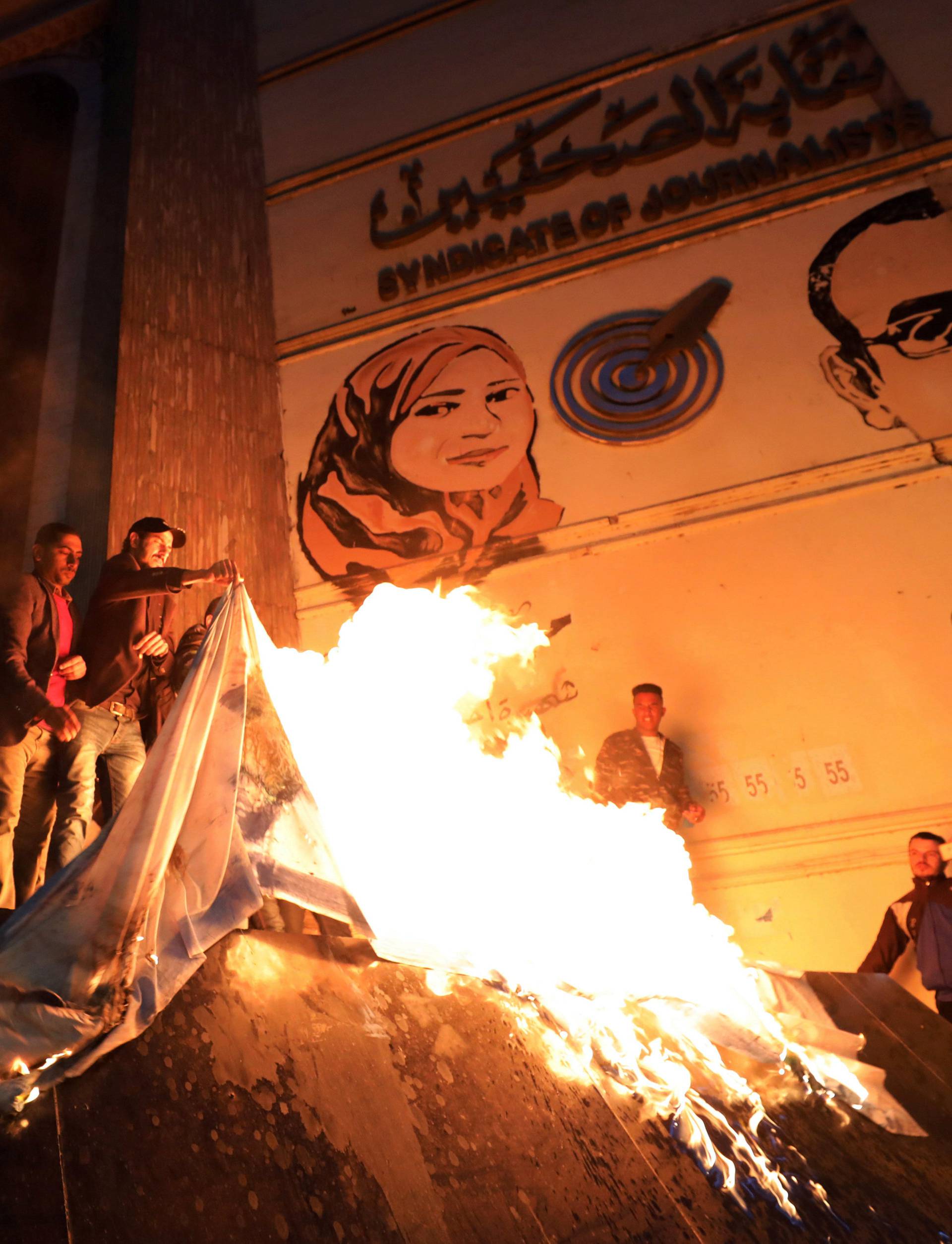 People shout slogans against Israel while burning a makeshift Israeli flag during a protest against Trump's Jerusalem declaration, in front of the Syndicate of Journalists in Cairo