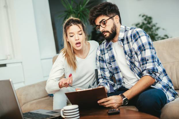 Woman and man doing paperwork together, paying taxes online on n