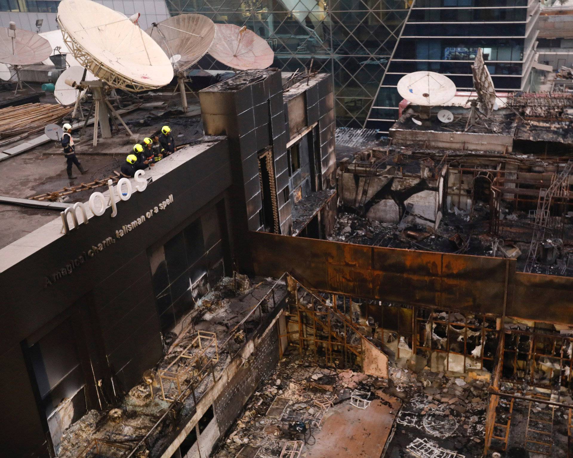 Fire fighters inspect the restaurants destroyed in a fire in Mumbai