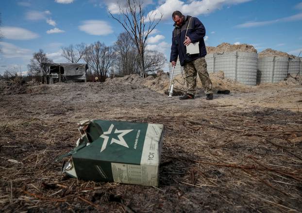 A dosimetrist measures the level of radiation around trenches dug by the Russian military in an area with high levels of radiation called the Red Forest near the Chernobyl Nuclear Power Plant, in Chernobyl