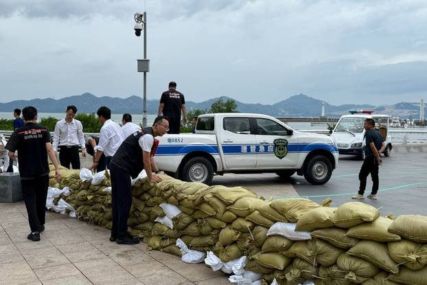 Emergency team members place sandbags at the Shekou waterfront as Super Typhoon Ragasa approaches, in Shenzhen