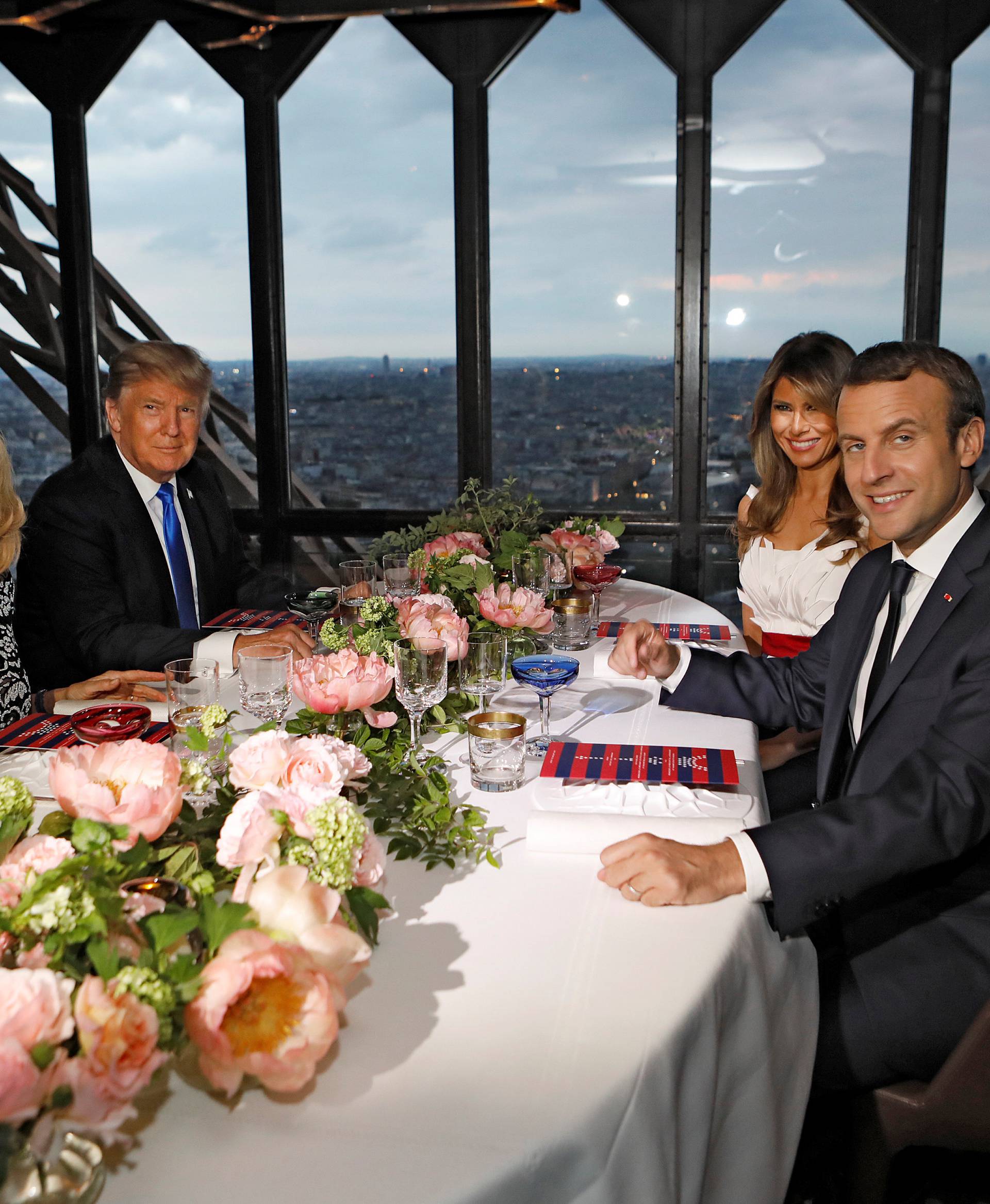 Brigitte Macron, wife of French President Emmanuel Macron, U.S. President Donald Trump and First lady Melania Trump pose at their table at the Jules Verne restaurant for a private dinner at the Eiffel Tower in Paris