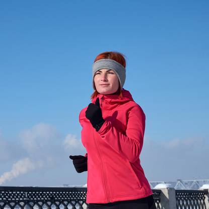 Running athlete woman sprinting during winter training outside in cold snow weather. Close up showing speed and movement