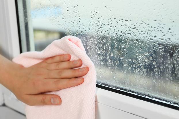 Woman,Wiping,Window,Glass,With,Drops,Of,Condensate,Indoors,,Closeup.
