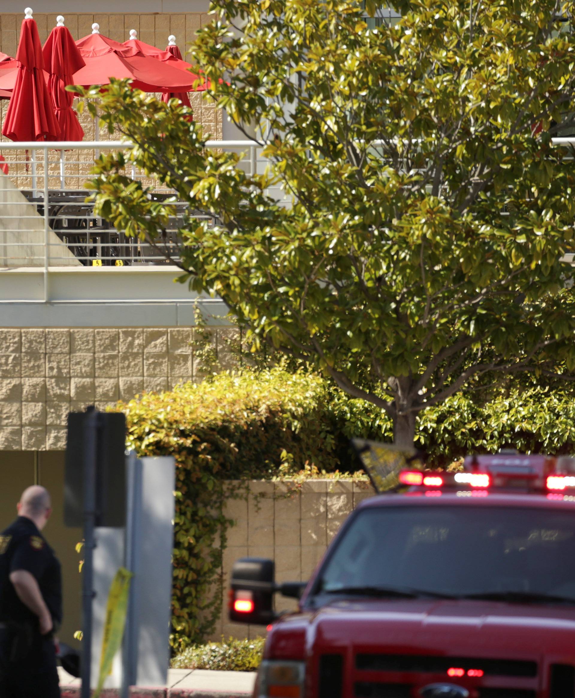 Law enforcement officers are seen near a patio with crime scene markers at Youtube headquarters following an active shooter situation in San Bruno, California