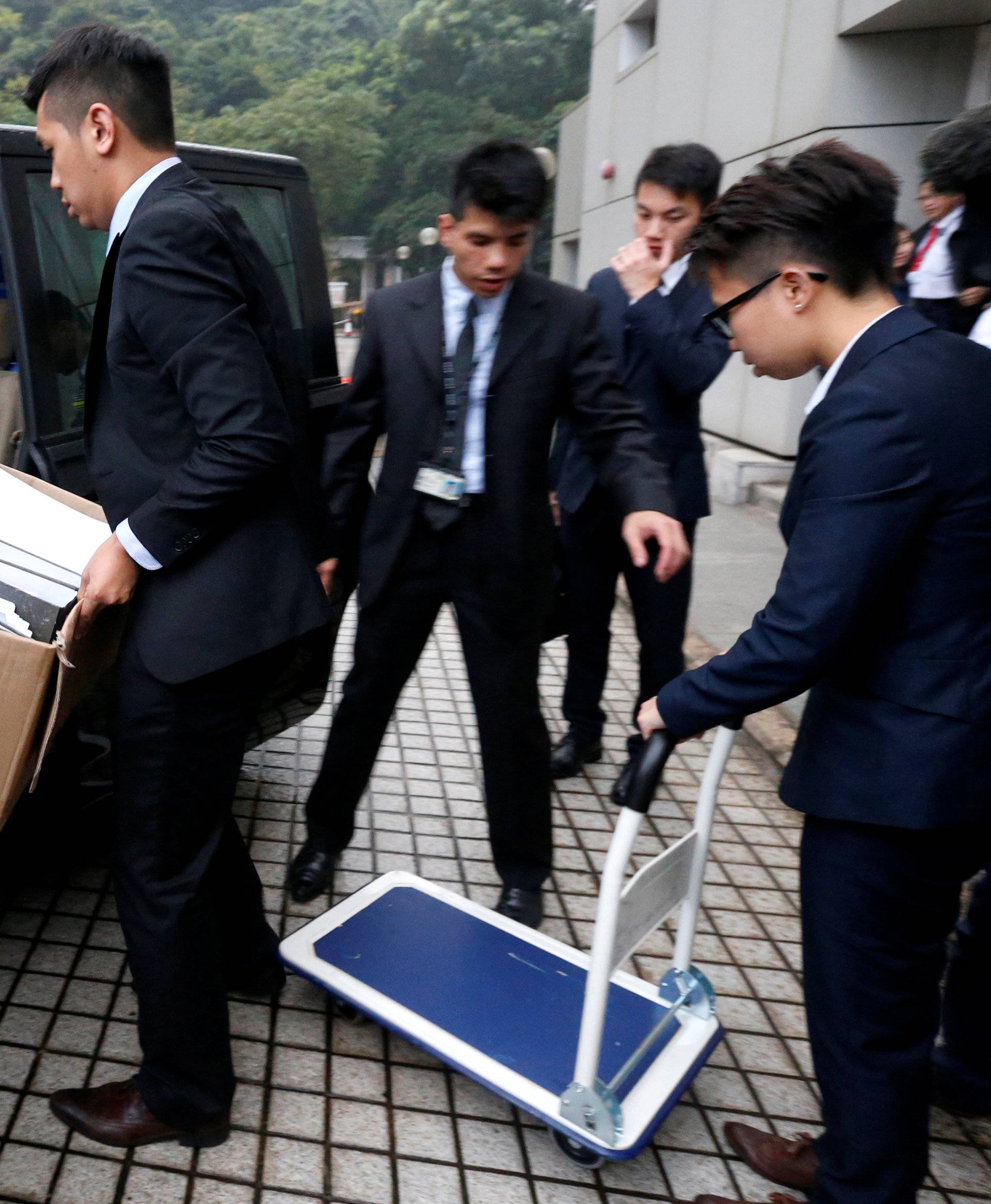 Police carry away documents relating to the double murder trial of British former banker outside High Court in Hong Kong