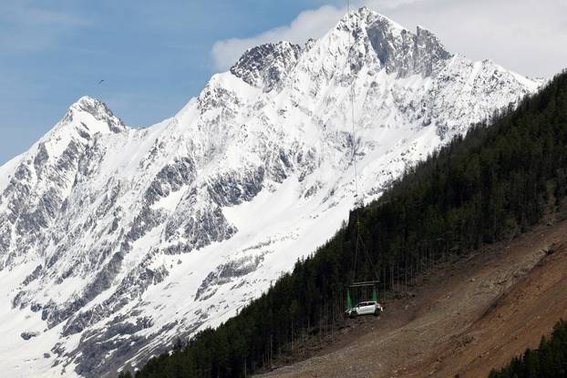 A car is carried by helicopter near Blatten