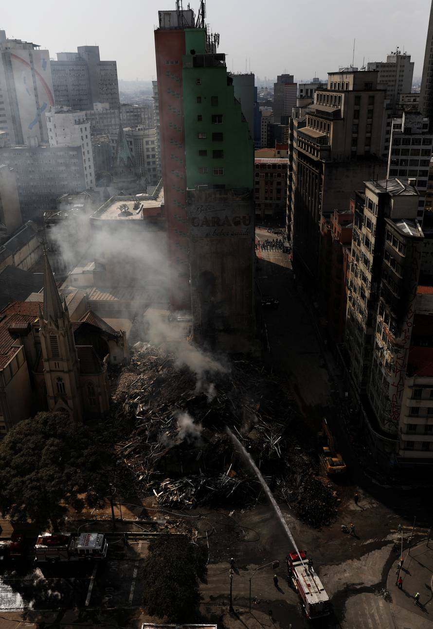 Firefighters try to extinguish the fire of a building that caught fire and collapsed in the center of Sao Paulo