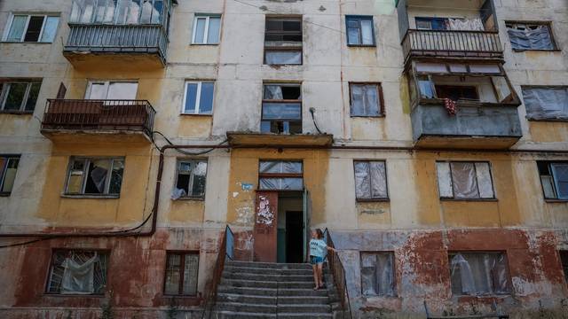 Volunteers of a charitable organisation replace broken by Russian military attacks windows with special frames, in Donetsk region