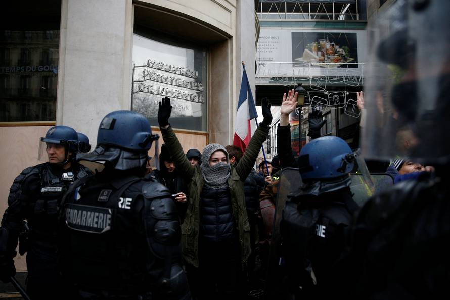 People face off with French Gendarmes as they demonstrate during a national day of protest by the "yellow vests" movement in Paris