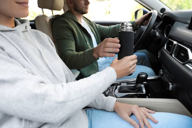 Woman,With,Thermos,On,Passenger,Seat,Of,Car,,Closeup