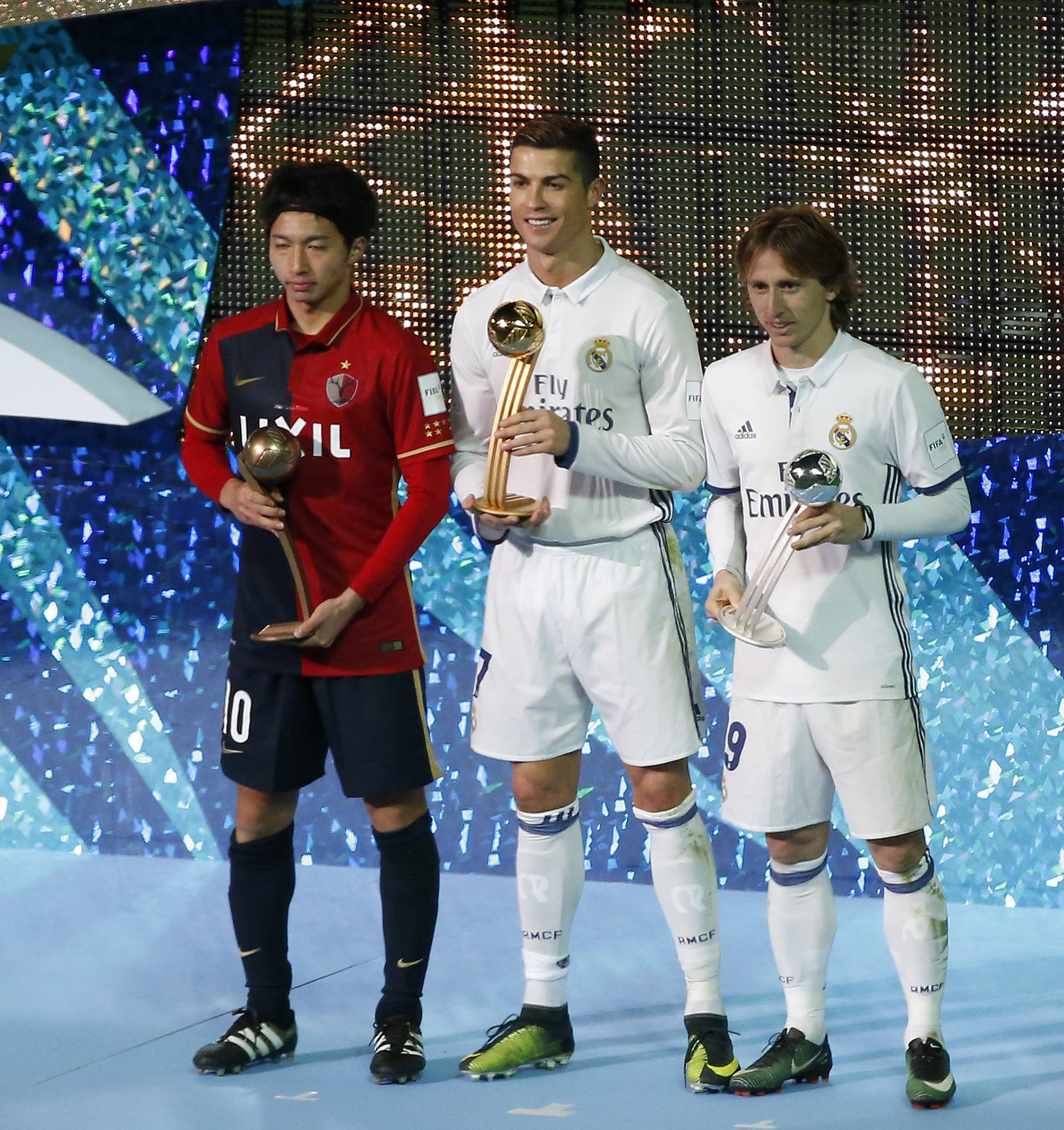 Real Madrid's Cristiano Ronaldo celebrates with the Golden Ball trophy, Real Madrid's Luka Modric with the Silver Ball trophy and Kashima Antlers' Gaku Shibasaki with Bronze Ball trophy