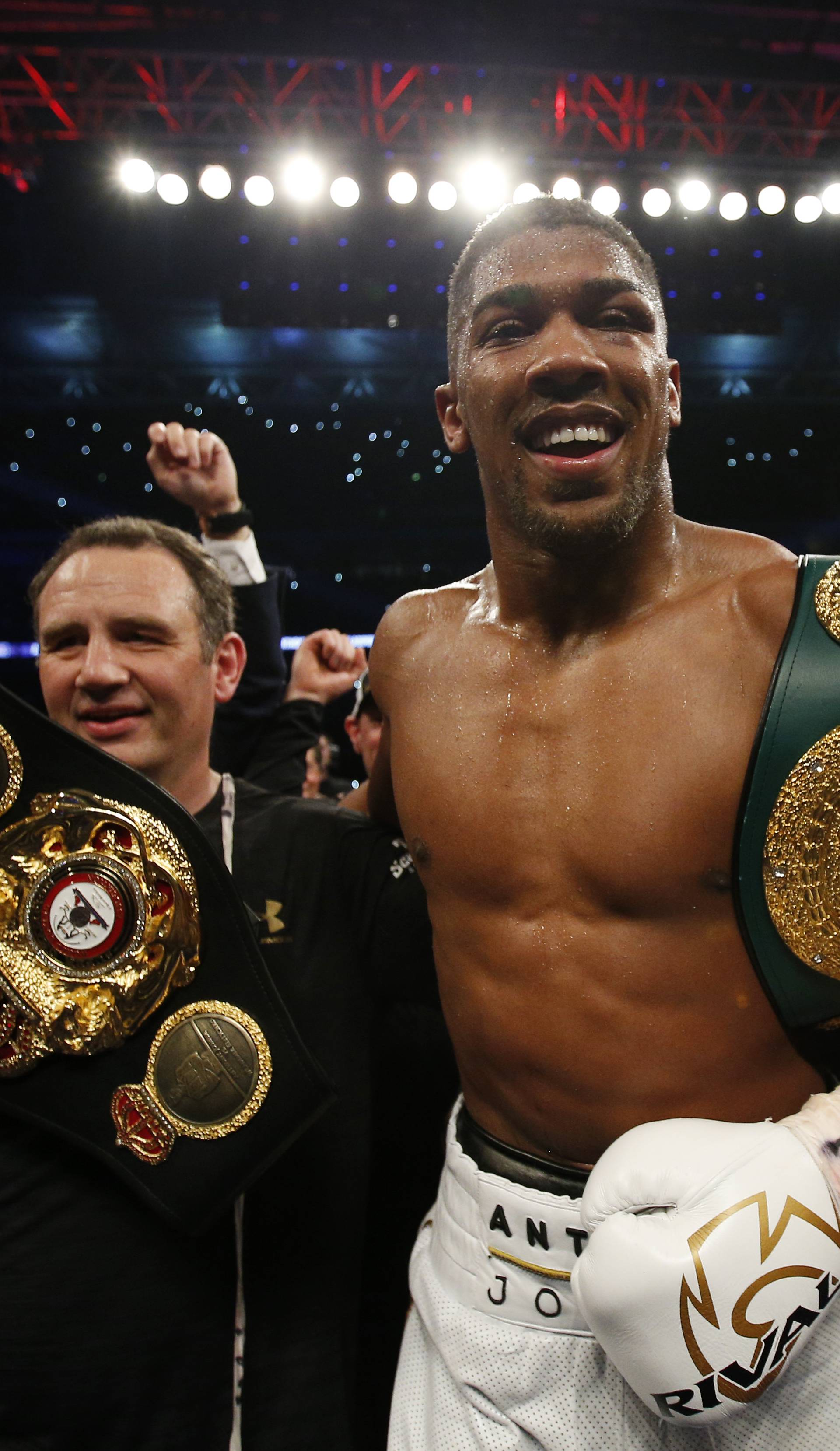 Anthony Joshua celebrates with trainer Robert McCracken after winning the fight