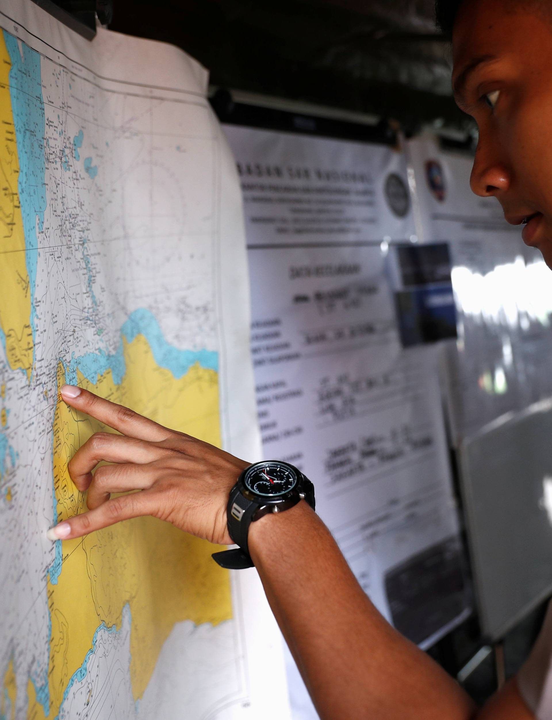 An Indonesian police officer studies a map in the search and rescue command center for the Lion Air flight JT610 crash, at Tanjung Priok port in Jakarta