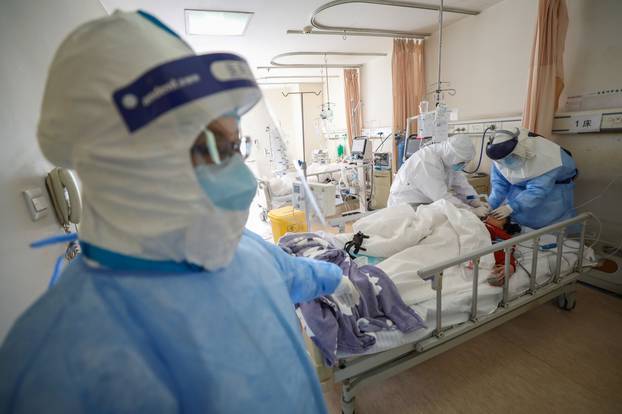 Medical workers in protective suits attend to a patient inside an isolated ward of Wuhan Red Cross Hospital in Wuhan, the epicentre of the novel coronavirus outbreak