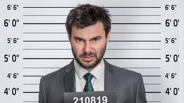 Mugshot of man in suit at police station