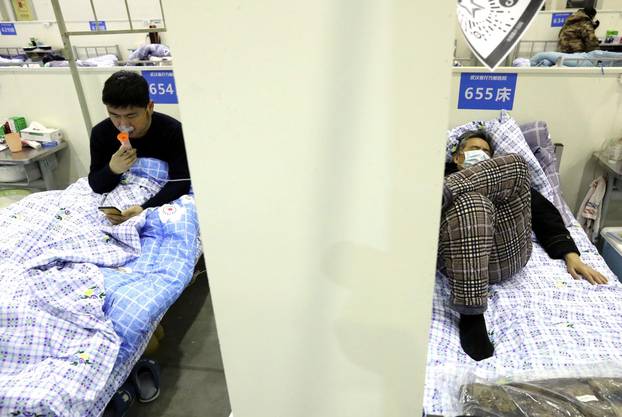 Patients rest on their beds inside the Wuhan Parlor Convention Center that has been converted into a makeshift hospital following an outbreak of the novel coronavirus