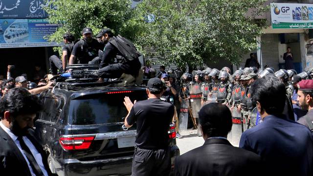 Pakistan security forces guard a vehicle carrying former Prime Minister Imran Khan after his arrest at a court in Islamabad
