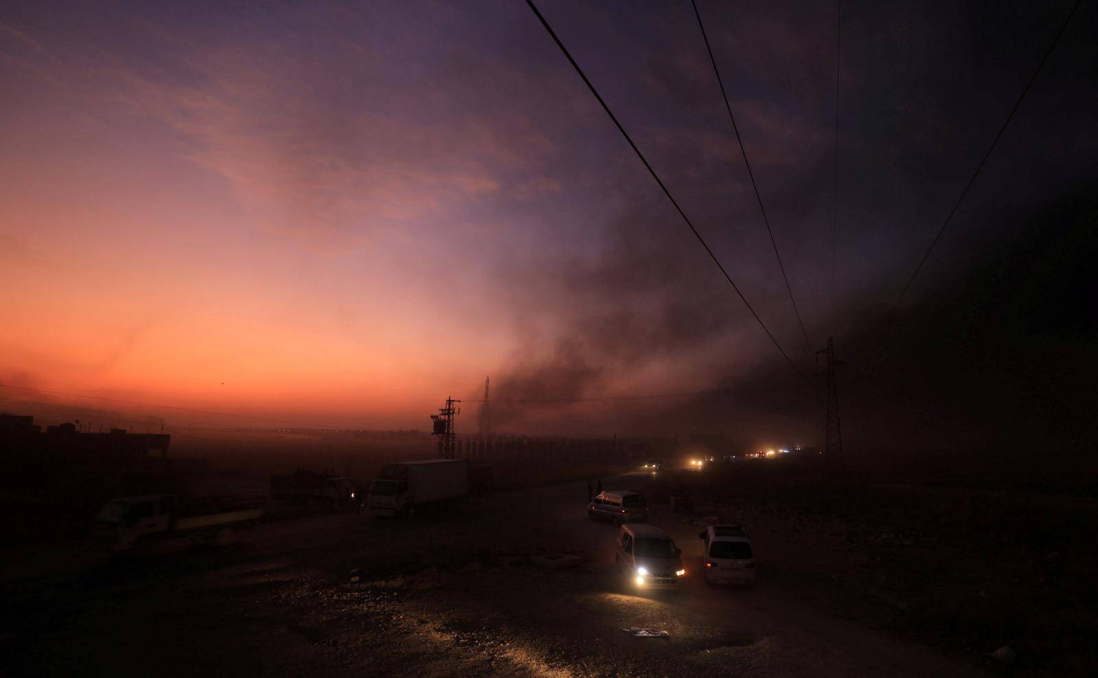 Vehicles are seen as people flee Ras al Ain town