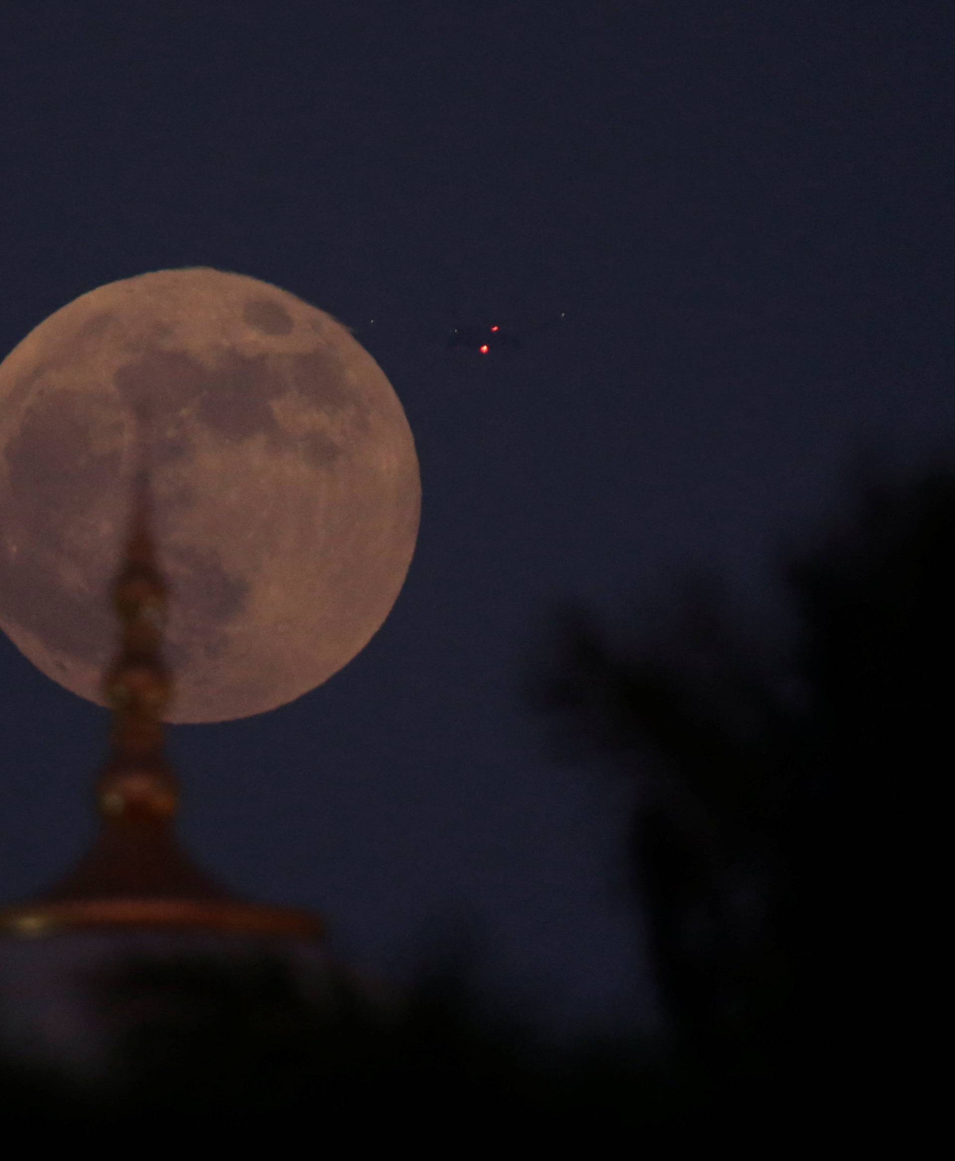 A lunar eclipse of a full "Blood Moon" rises behind the Sheikh Zayed Grand Mosque in Abu Dhabi