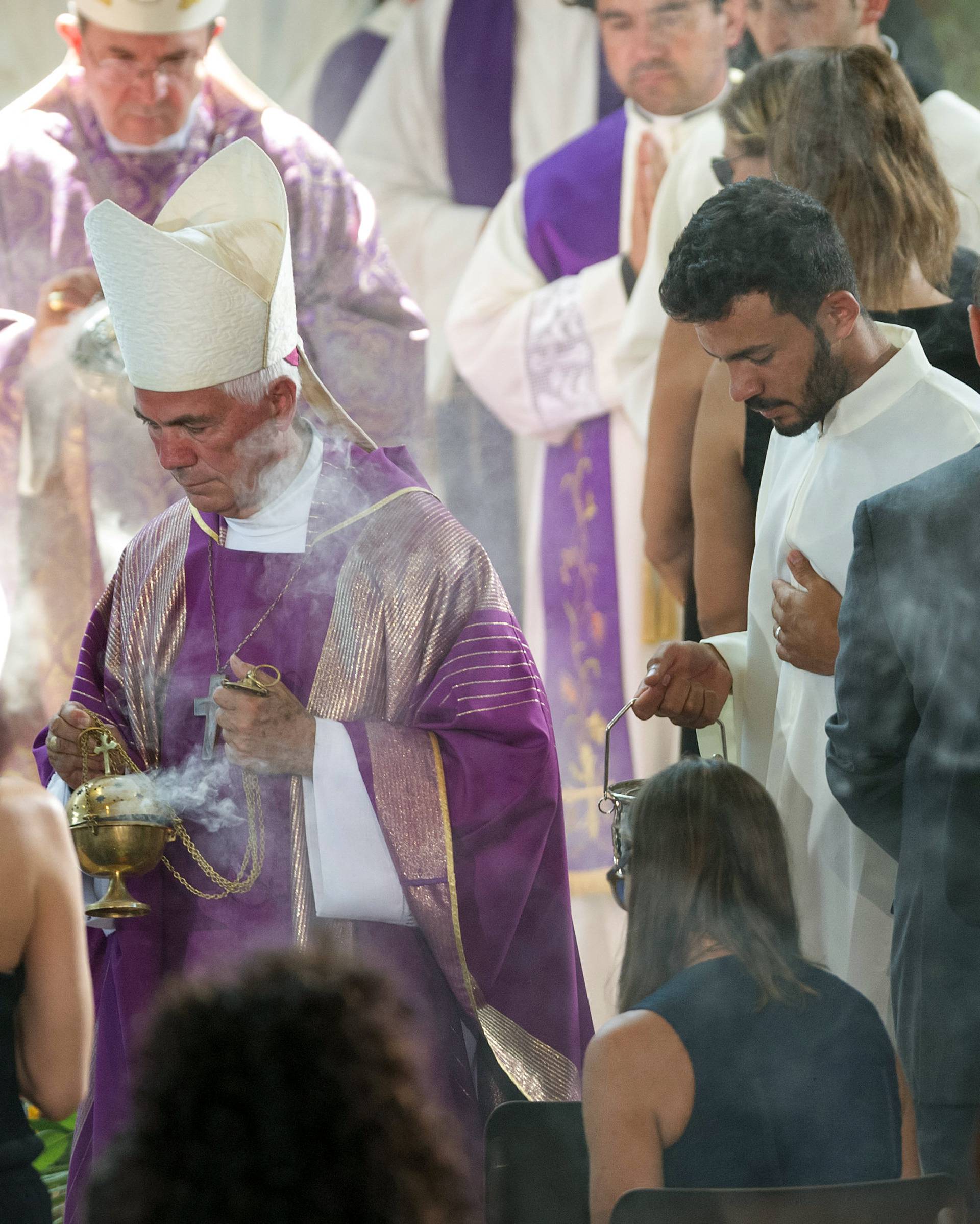 Giovanni D'Ercole, bishop of Ascoli Piceno, spreads incense during a funeral service for victims of the earthquake inside a gym, Italy