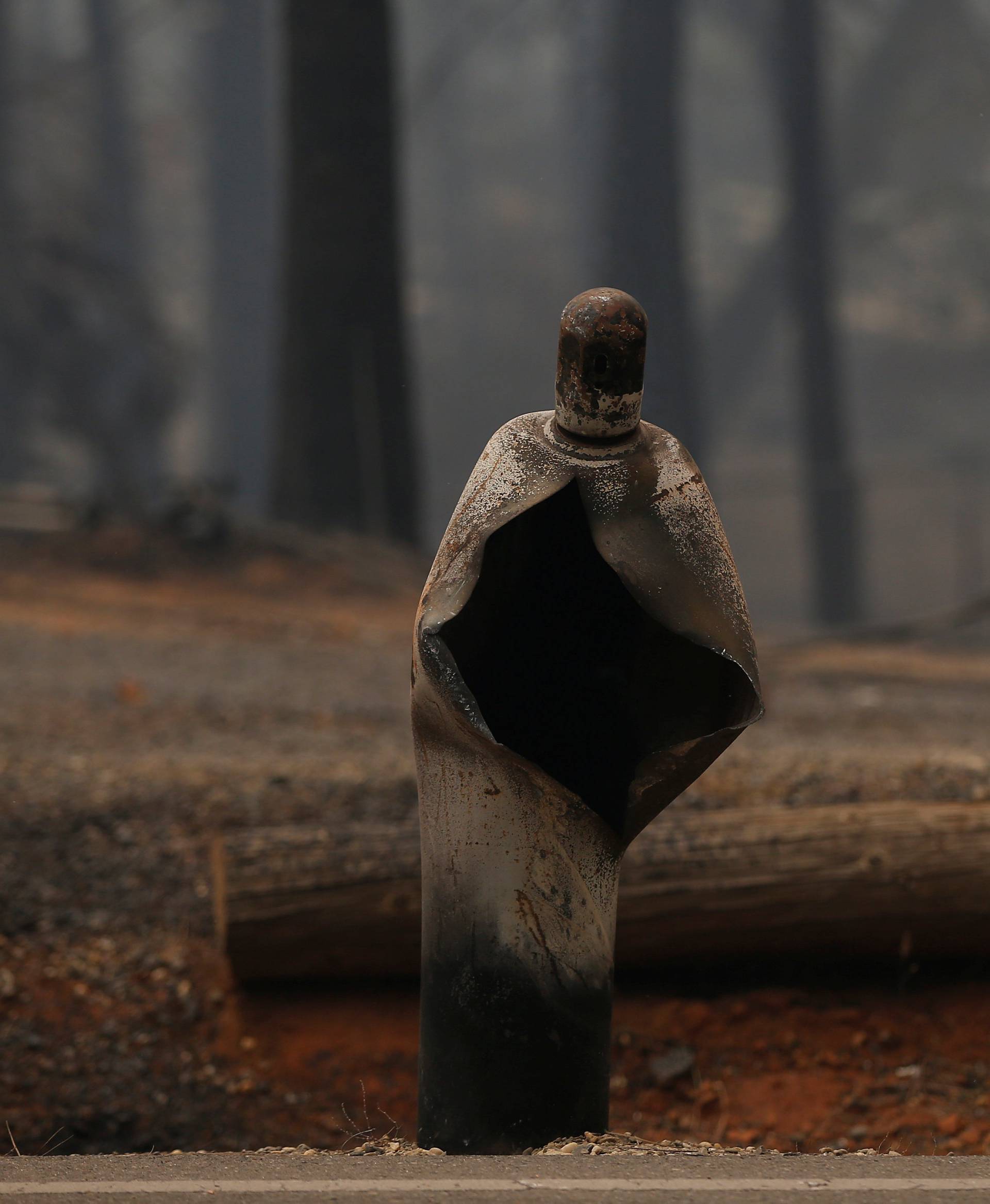 A mangled gas canister is seen along a road during the Camp Fire in Paradise