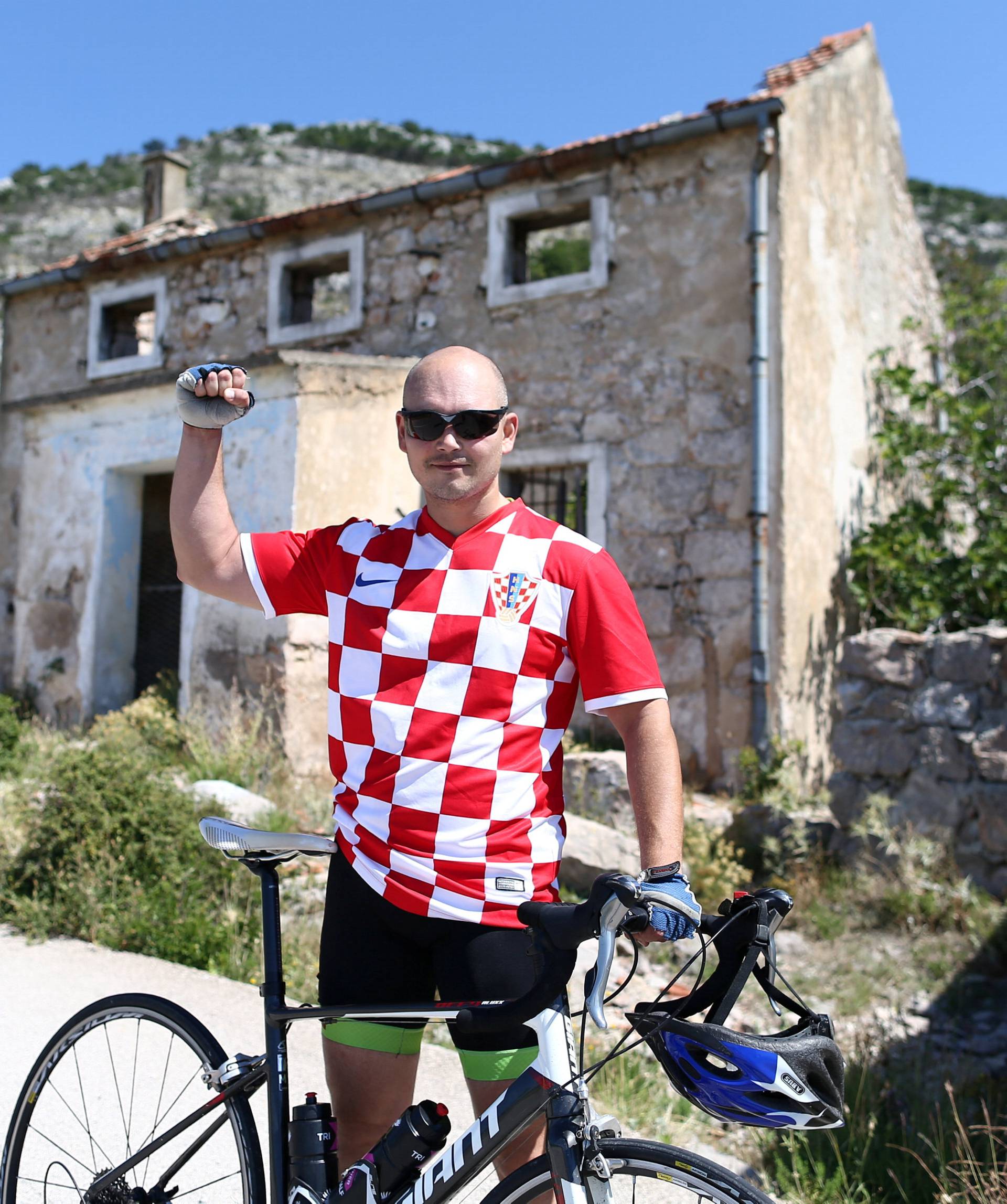 Man poses in front of Luka Modric's birth house in Modrici village