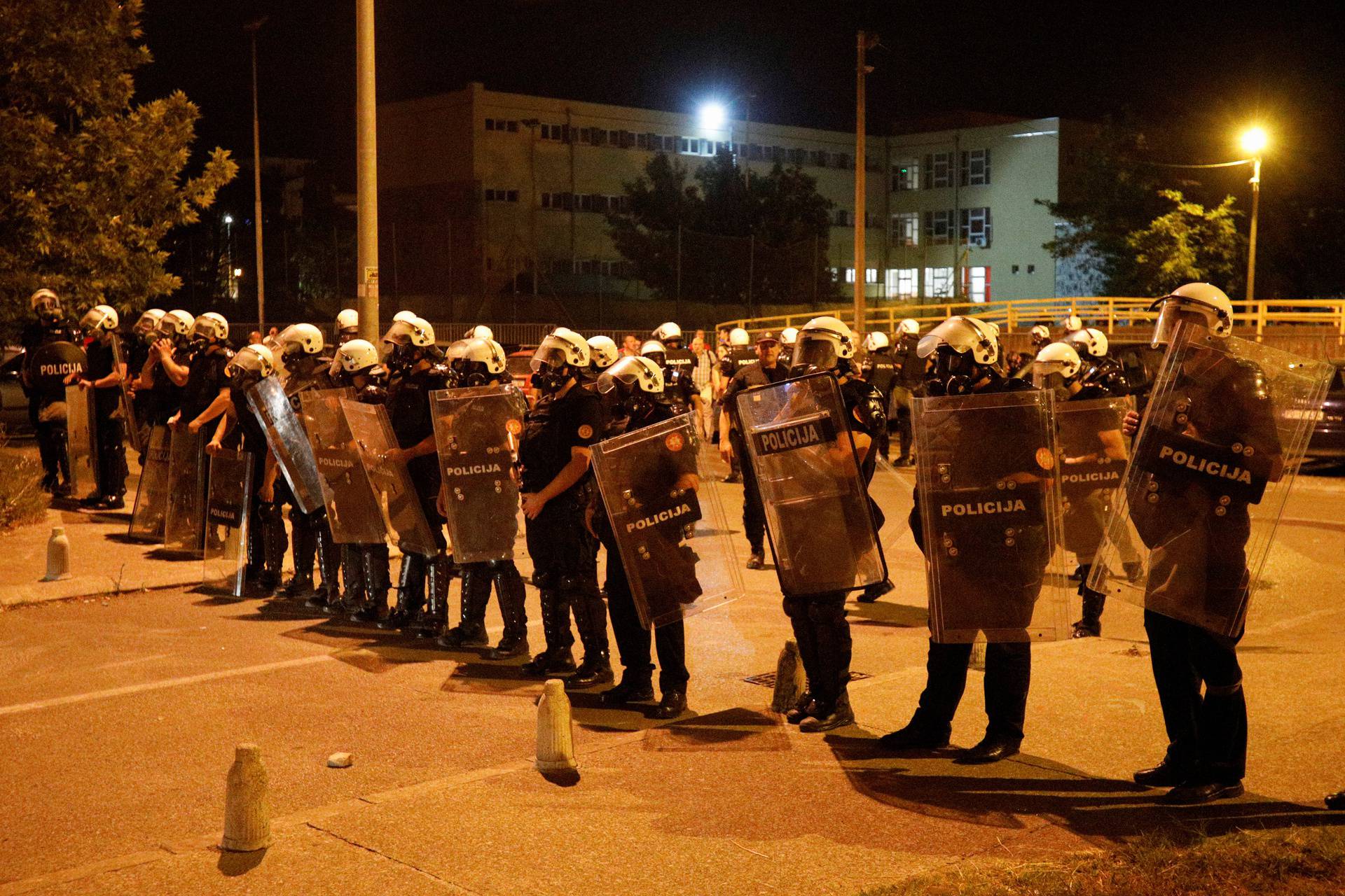 Riot police hold a line in front of a police station in Podgorica