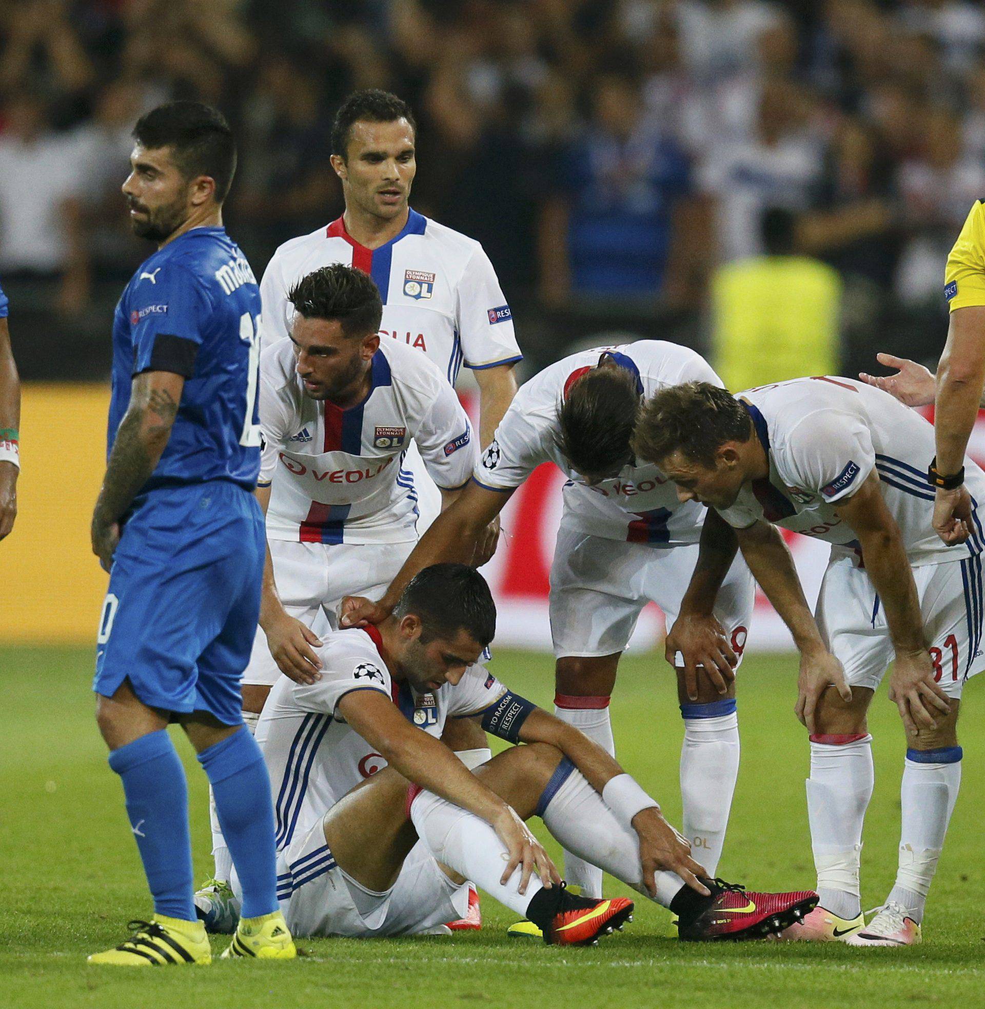 Olympique Lyon's player look at injured team mate Maxime Gonalons during match against Dinamo Zagreb