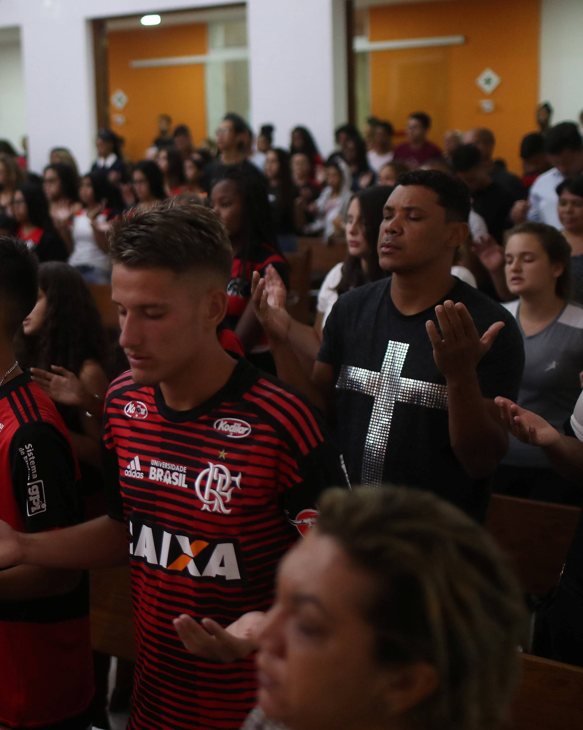 Supporters of Flamengo pray during a mass in memory of the victims of the club's training center deadly fire in Rio de Janeiro
