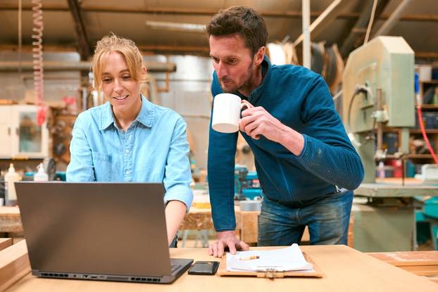 Male,And,Female,Carpenters,Working,In,Woodwork,Workshop,Using,Laptop